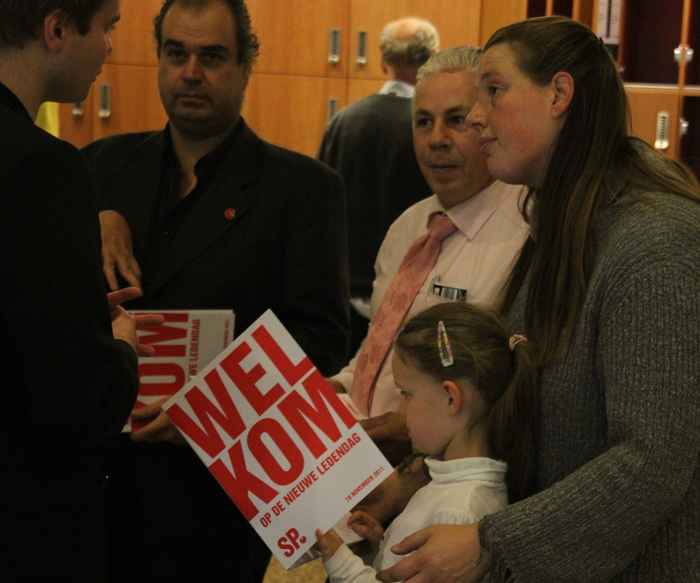 meisje met SP vlag staat met haar moeder een gesprek te voeren met een andere man