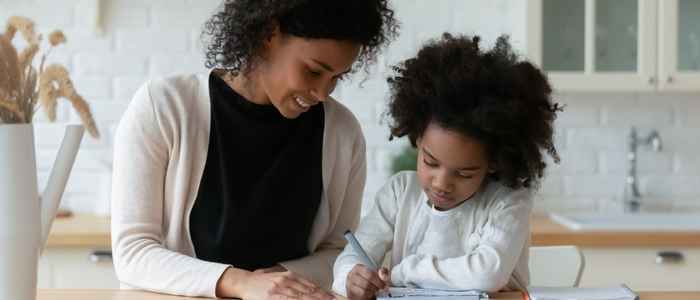 mother is helping her daughter with home schooling