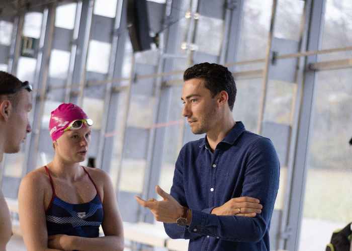 Sportpsycholoog Yannick Balk in gesprek met zwemmers in het Sloterparkbad (foto: NSP)