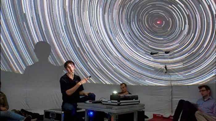 A young person pointing to a picture with star trails
