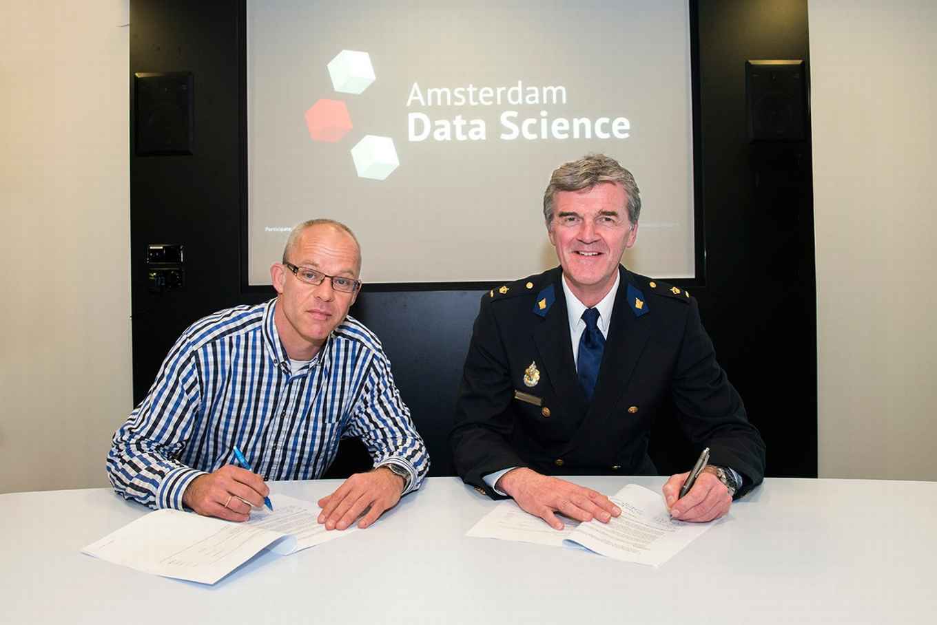 De politie en de UvA ondertekenen een samenwerkingscontract.