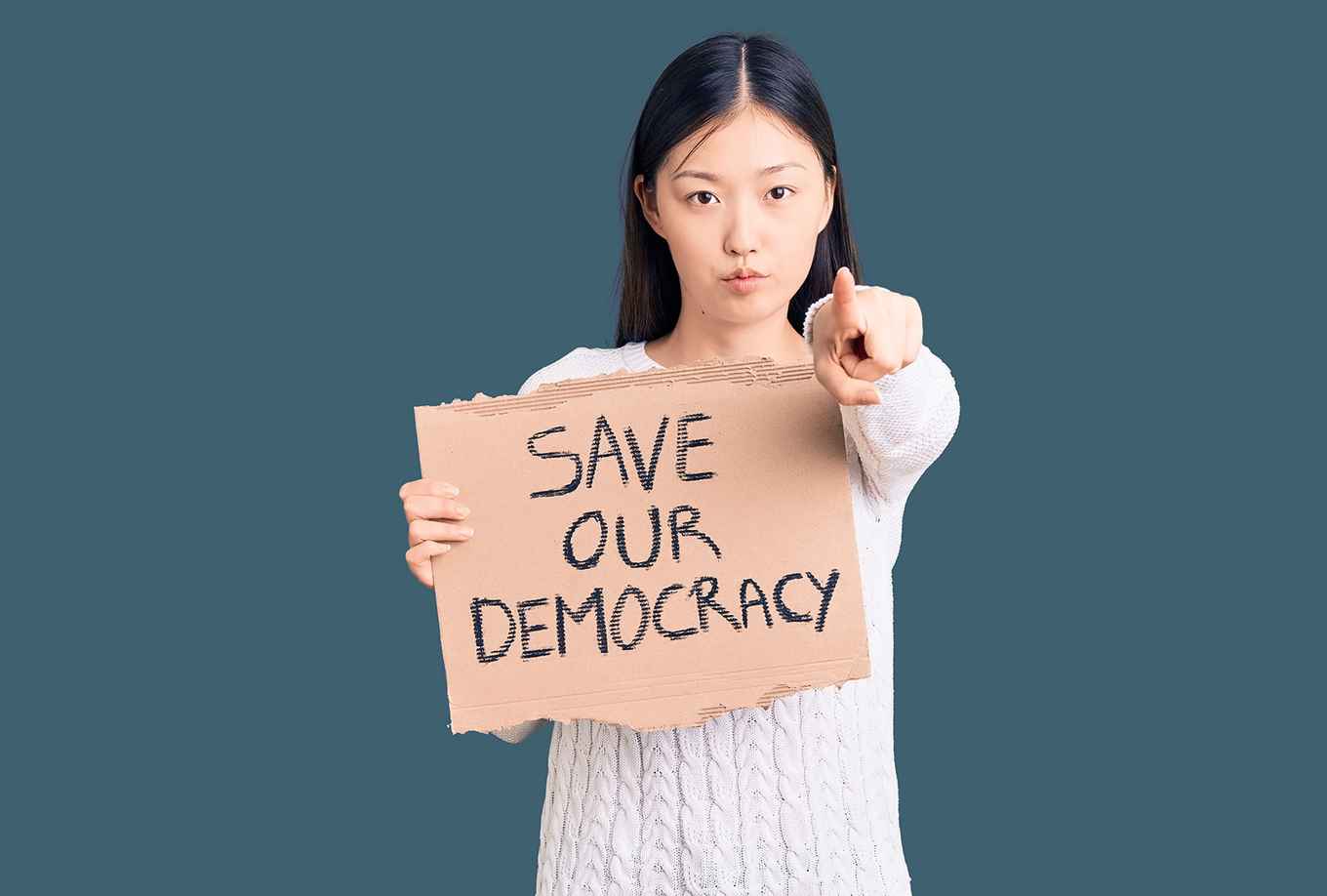girl holding cardboard on which is written 'Save our democracy'