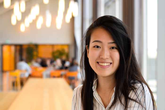 Student smiling at camera with lights in the background