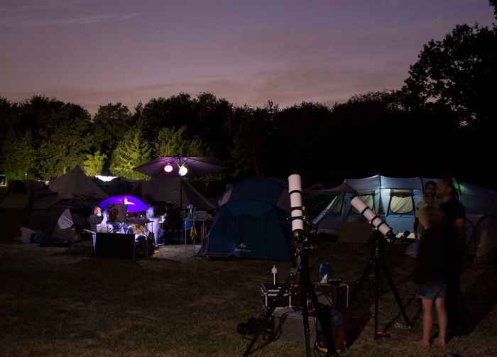 Image of two telescopes in the dark surrounded by tents