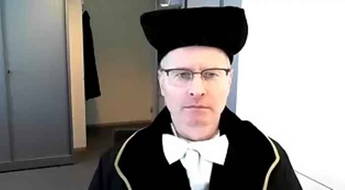 Roel Beetsma in gown behind his computer