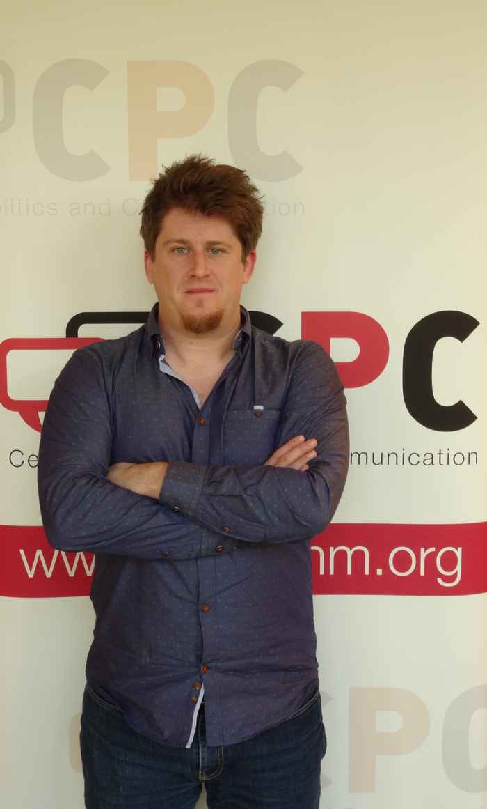 Lecturer with folded arms looking directly at camera