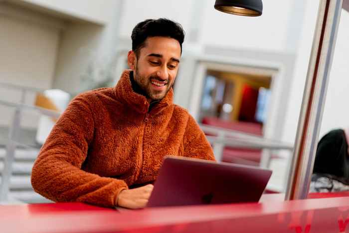 Student at laptop computer smiling