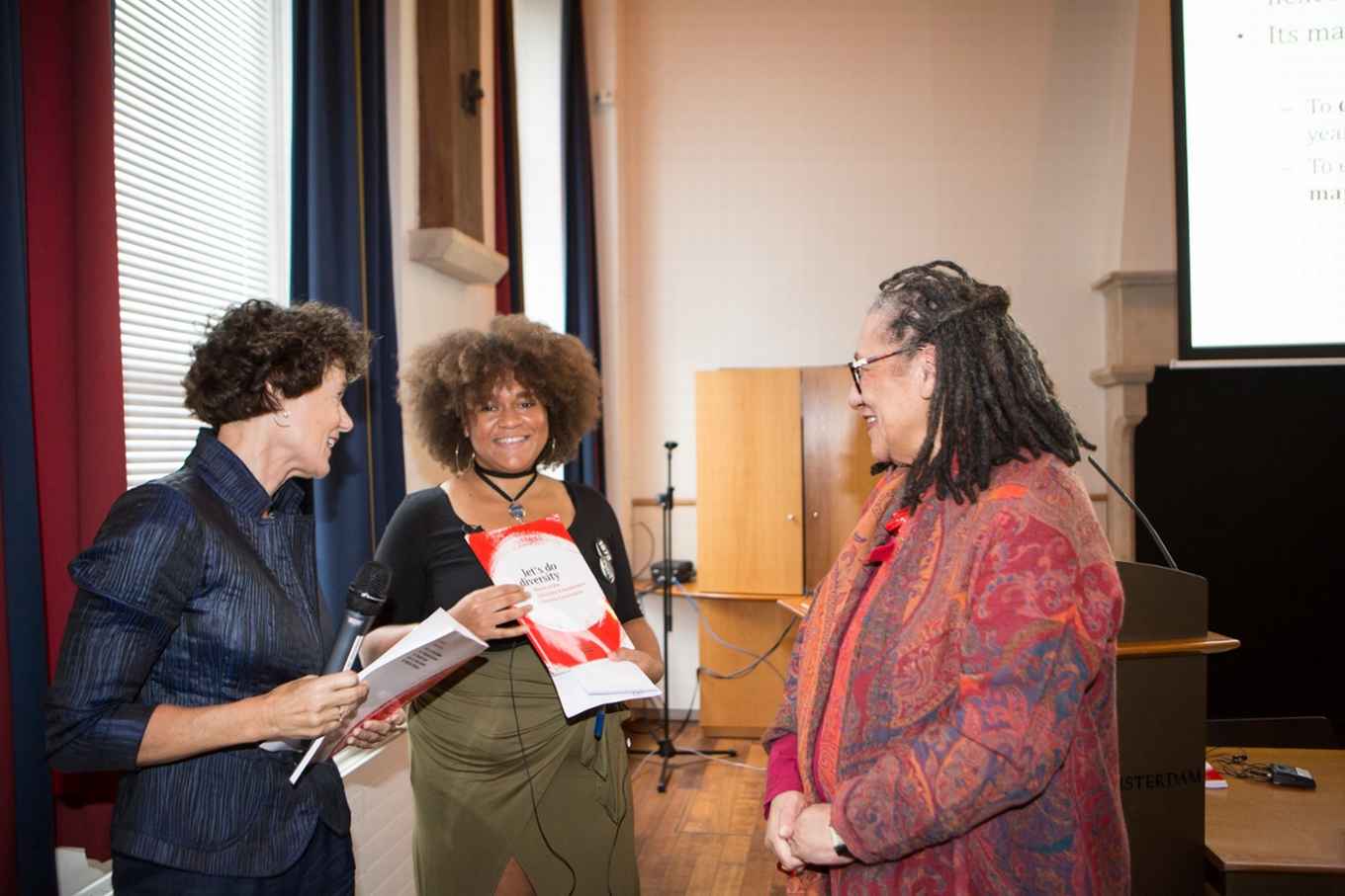 Stralende vertegenwoordiger Alfie Vanwyngarden na in ontvangst nemen van eindrapport 'Let's do Diversity' van de commissie Diversiteit uit handen van voorzitter Gloria Wekker. Links Geert ten Dam, voorzitter CvB UvA.