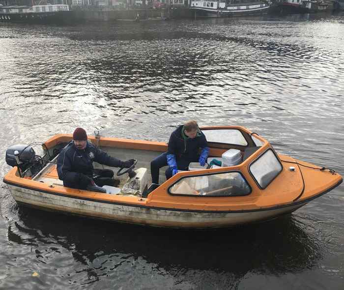 Wetenschappers op boot in gracht